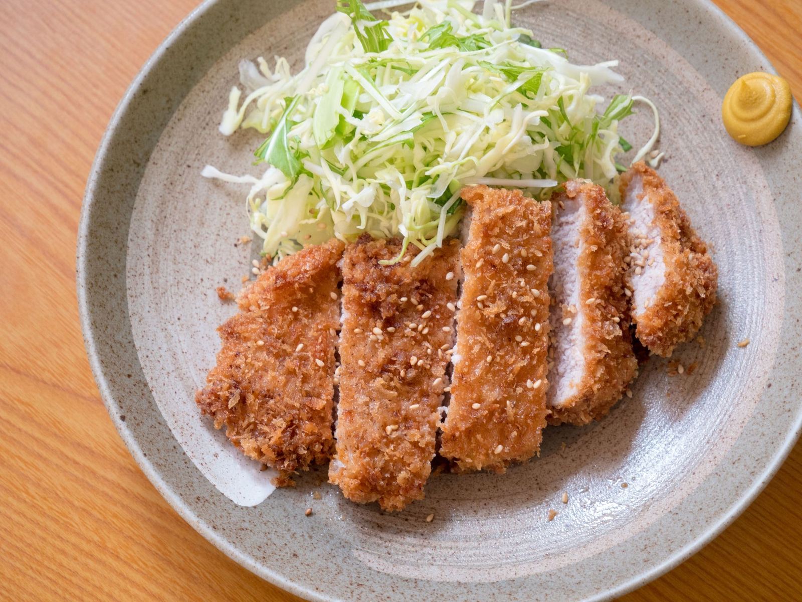 味噌だれをかけて切り分けたロースカツ。千切りキャベツと辛子